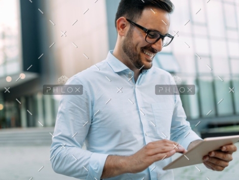 demo-attachment-815-portrait-of-businessman-in-glasses-holding-tablet-AWVHCJU